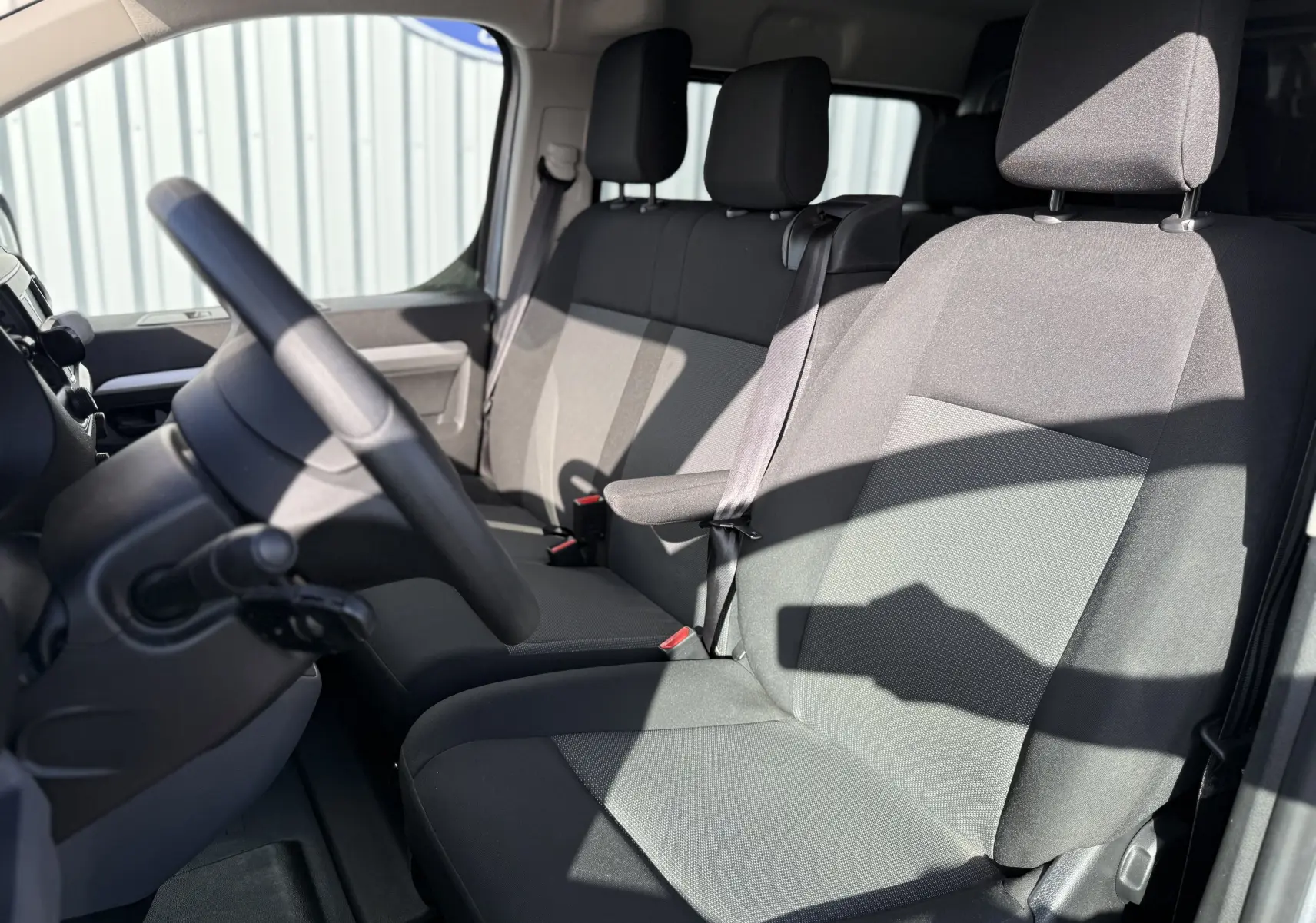 Vue intérieure côté conducteur du Fiat Scudo cabine approfondie 2022, sièges tissu gris et volant multifonction.