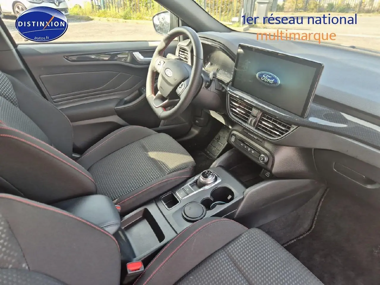 Intérieur avant droit de la Ford Focus 2024 gris magnétique, volant cuir sport et écran tactile central visible.
