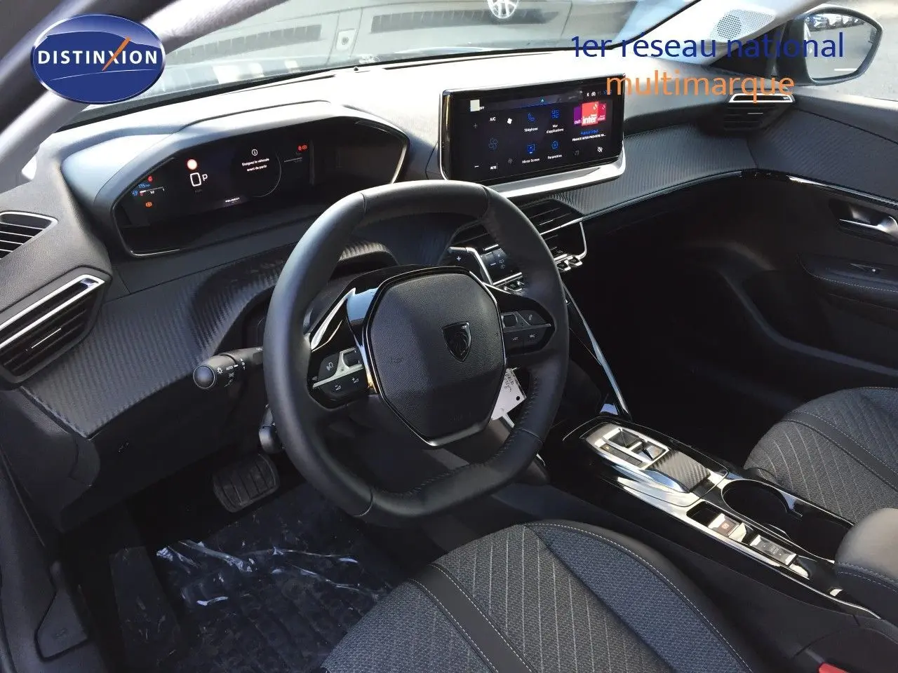 Intérieur moderne de la Peugeot 208 hybride 2025, vue côté conducteur sur le tableau de bord et volant noir.