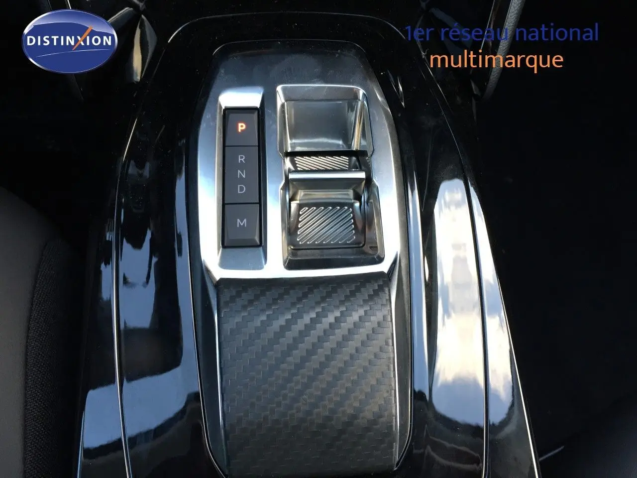 Gros plan sur la console centrale avec levier de vitesses automatique et finition carbone du Peugeot 208 gris selenium 2025.