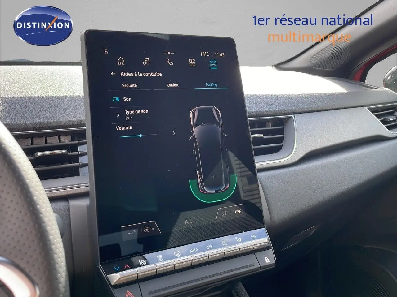 Vue rapprochée de l'écran tactile central du tableau de bord du Renault Captur rouge passion 2025, affichant les aides à la conduite.