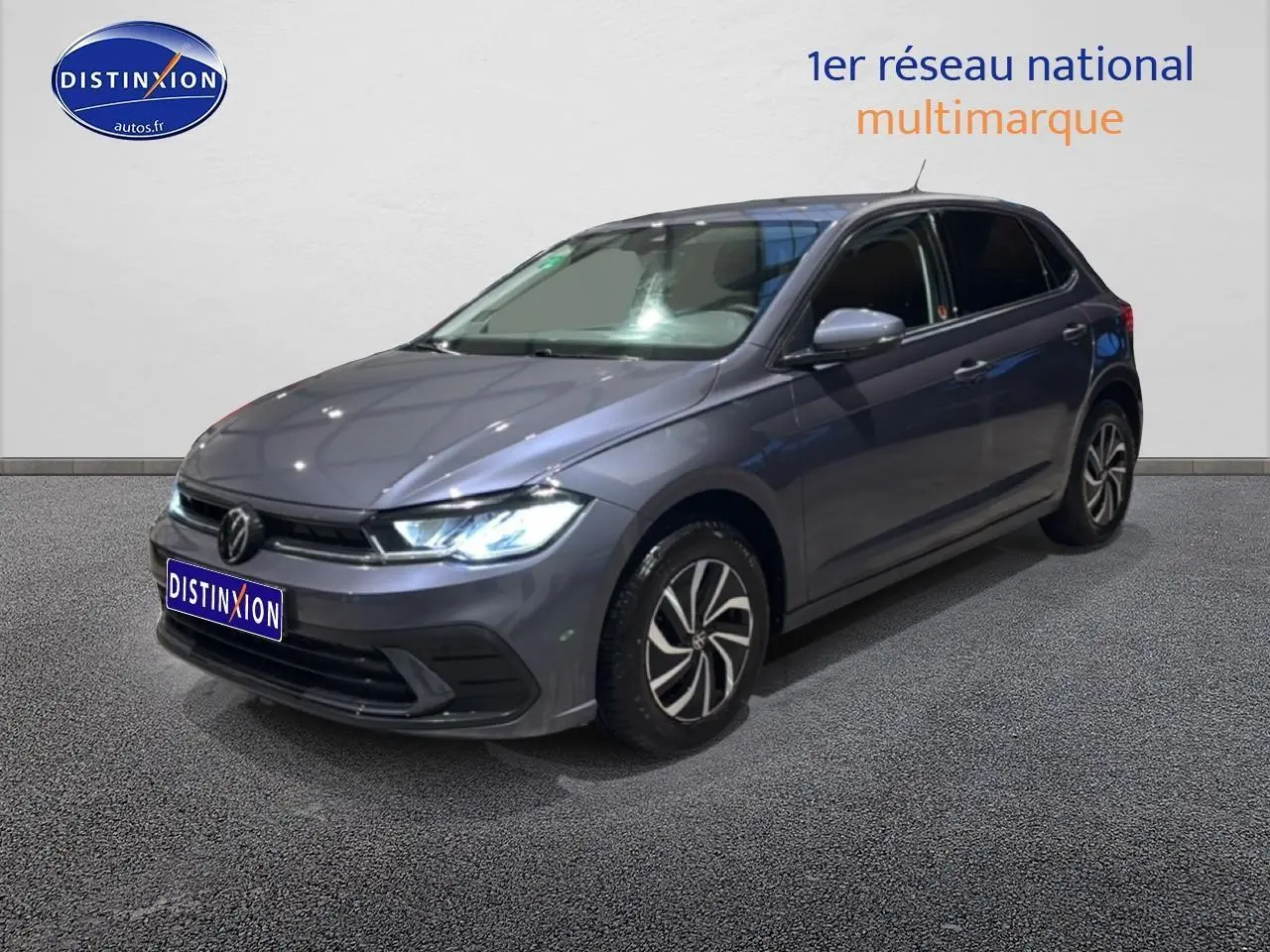 Volkswagen Polo gris cendre vue 3/4 avant droit avec phares LED allumés sur fond neutre.