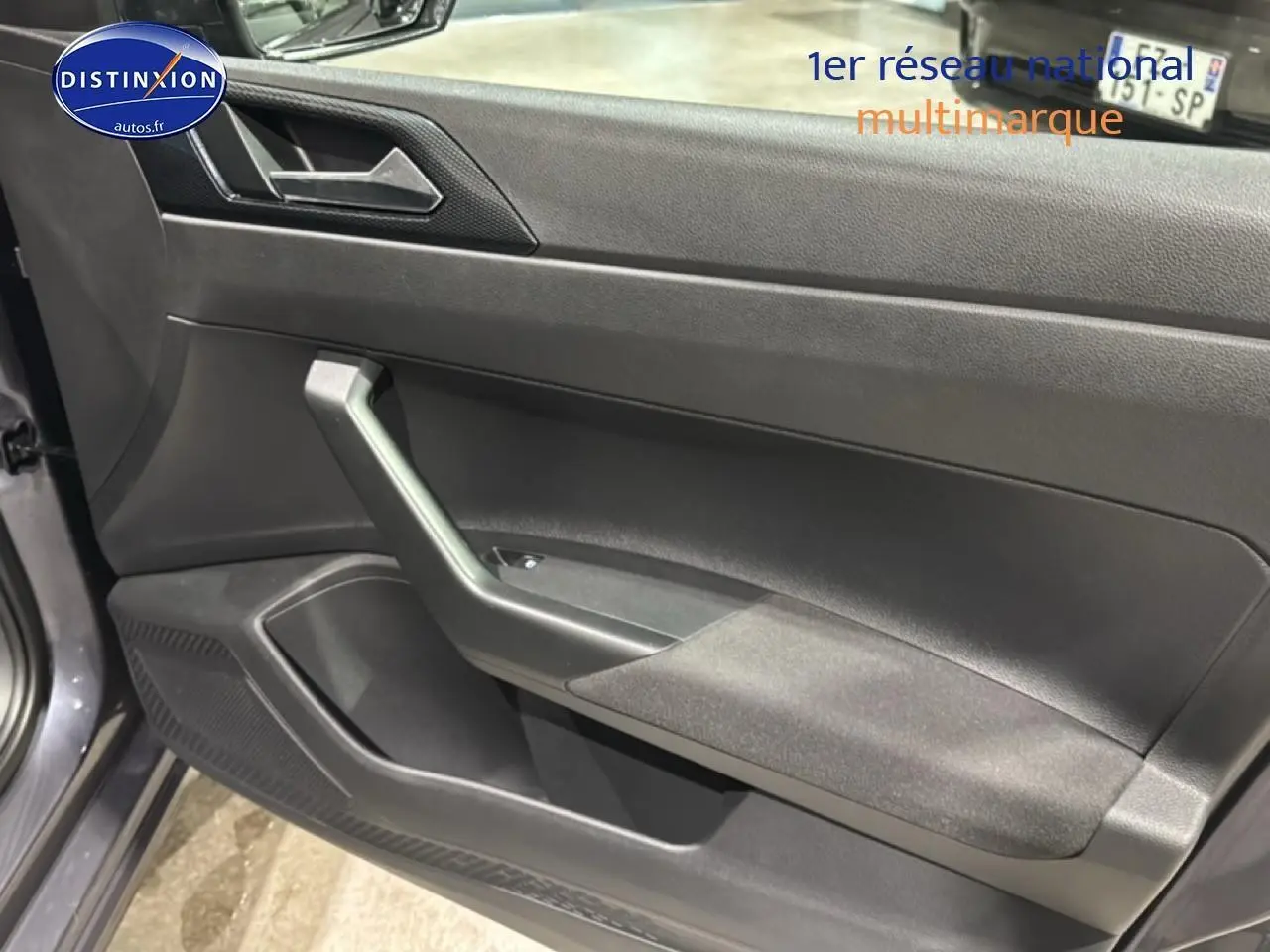 Vue intérieure côté gauche de la porte avant gris cendre de la Volkswagen Polo 2025 avec accoudoir et haut-parleur intégré.