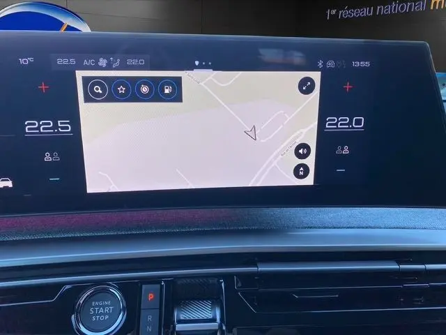 Écran tactile central du tableau de bord du Peugeot 5008 Hybrid 145 GT, affichant la navigation et la climatisation.