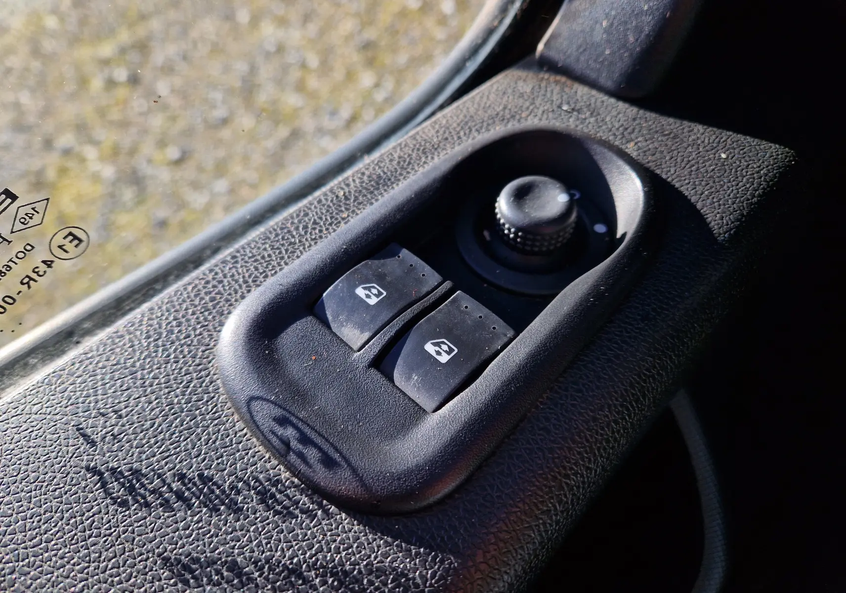 Gros plan sur les commandes de lève-vitres et réglage des rétroviseurs côté conducteur du Renault Master blanc.