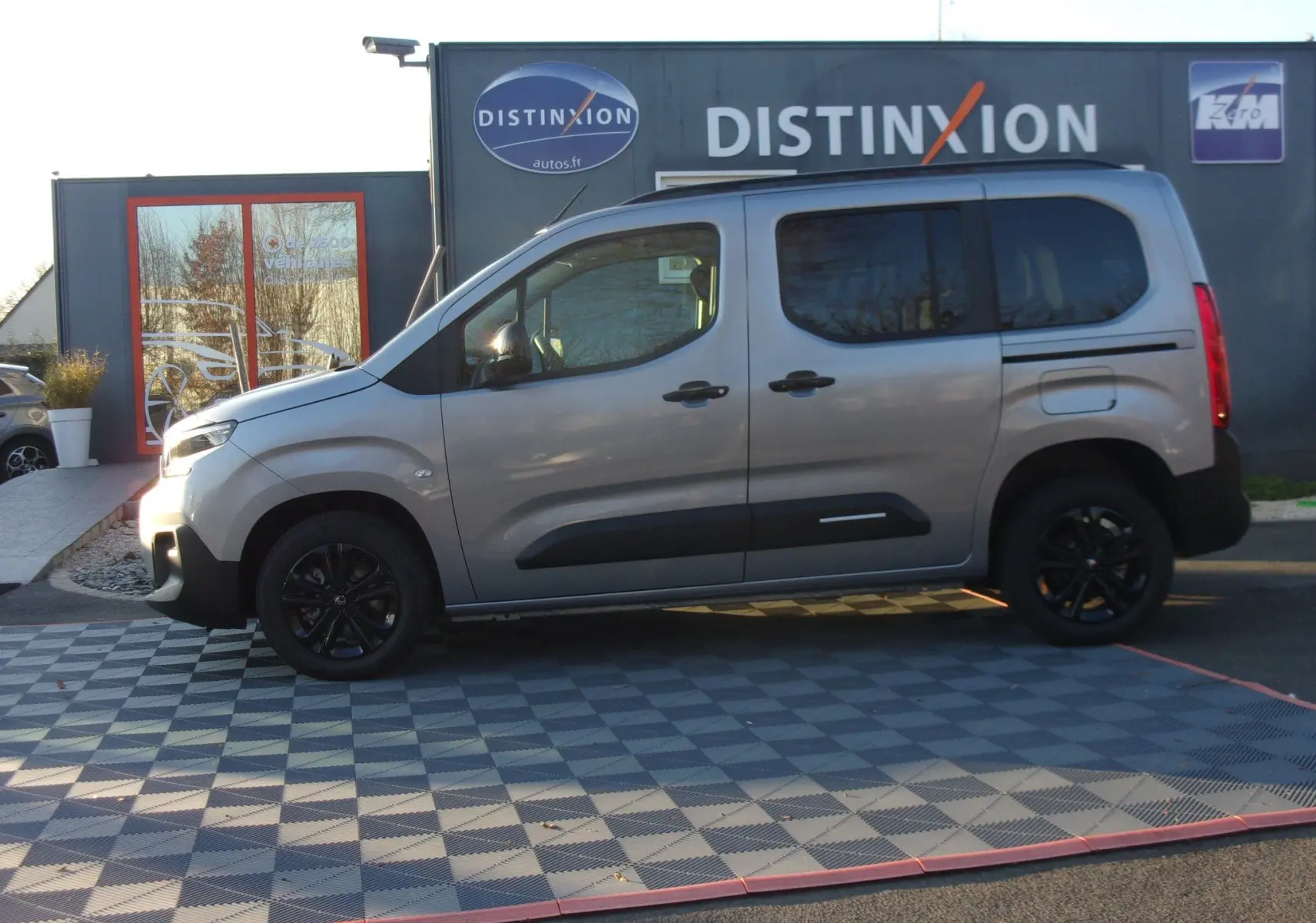Vue latérale droite du Citroën Berlingo gris Artense 2025 avec jantes noires et protections latérales noires.