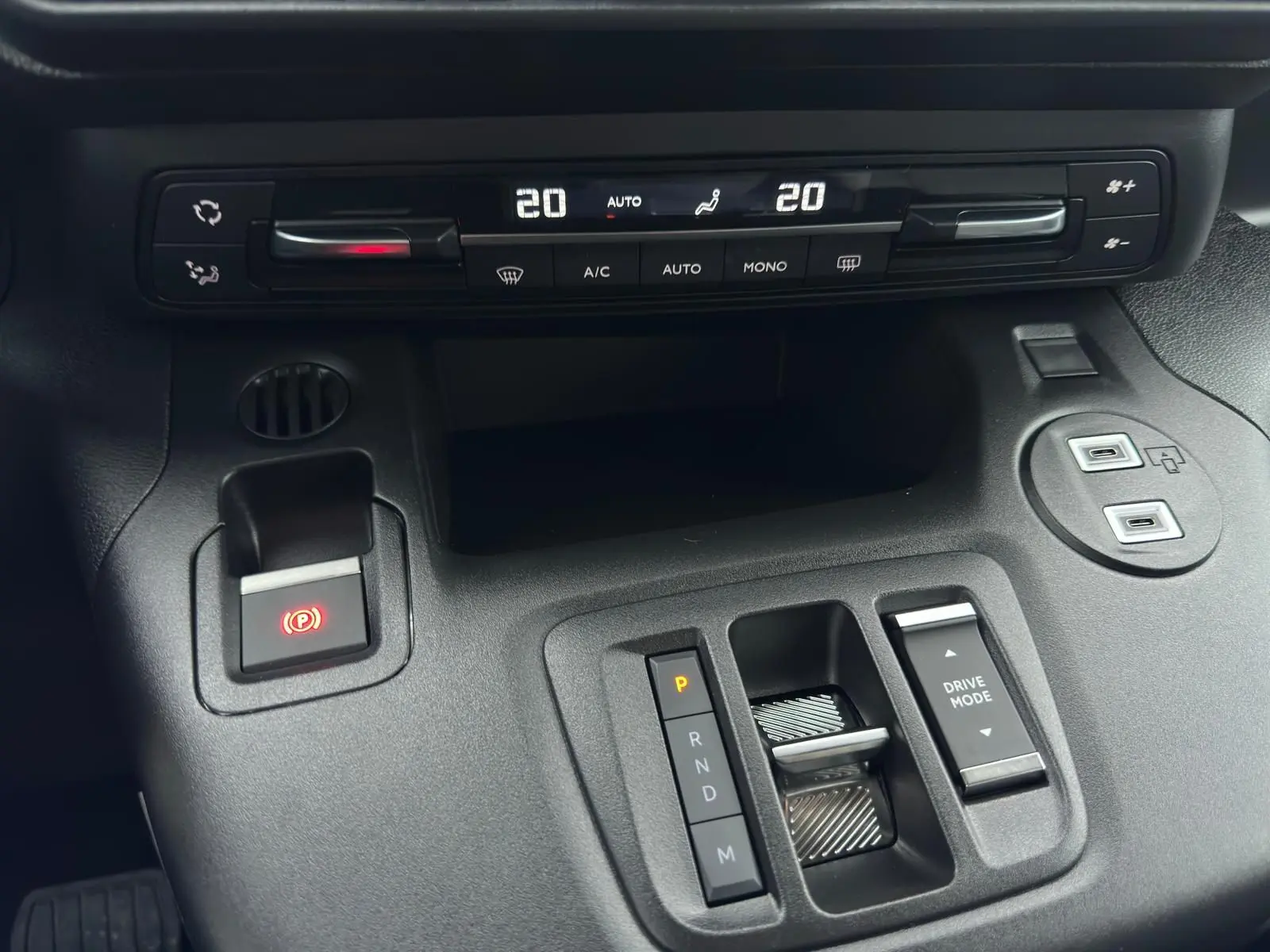 Vue rapprochée de la console centrale du Citroën Berlingo gris Artense 2025, avec commandes climatisation et boîte auto.