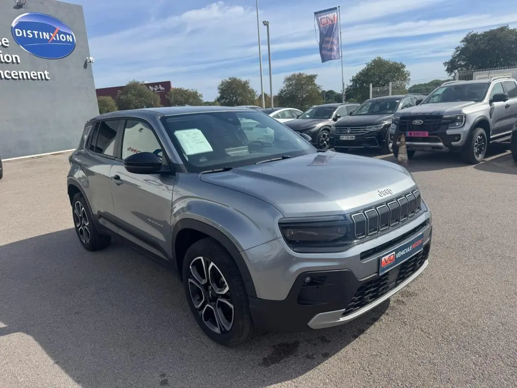 Jeep Avenger gris foncé vue 3/4 avant droit, avec calandre distinctive et jantes alliage noires.