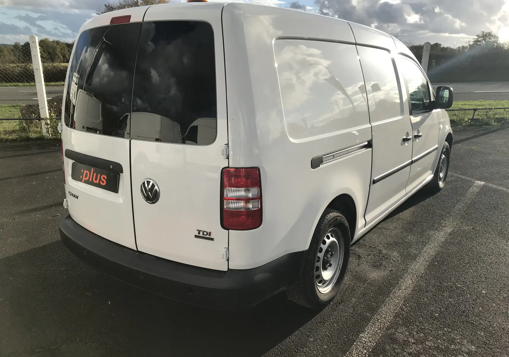 Vue 3/4 arrière droite d'un utilitaire blanc Volkswagen Caddy Maxi Van Frigo avec feux arrière rouges et toit surélevé.