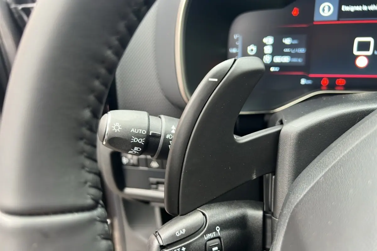 Gros plan sur la palette de changement de vitesse et le commodo d'éclairage du tableau de bord du Citroën C5 Aircross 2025.