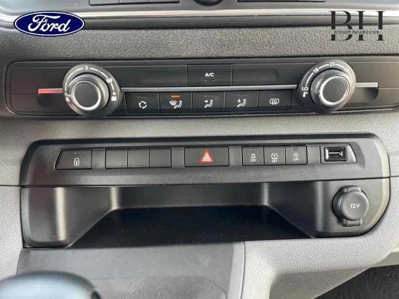 Tableau de bord du Peugeot Expert Fourgon blanc, vue centrée sur les commandes de climatisation et les boutons fonctionnels.