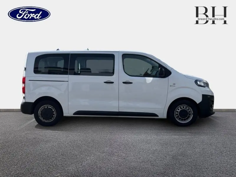 Profil droit d'un Peugeot Expert Fourgon blanc Banquise 2017 avec vitres teintées et porte latérale coulissante visible