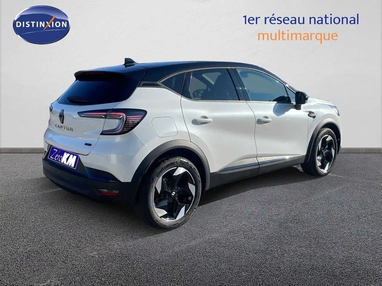 Vue 3/4 arrière droite d'un Renault Captur blanc nacré avec toit noir et jantes noires distinctives.