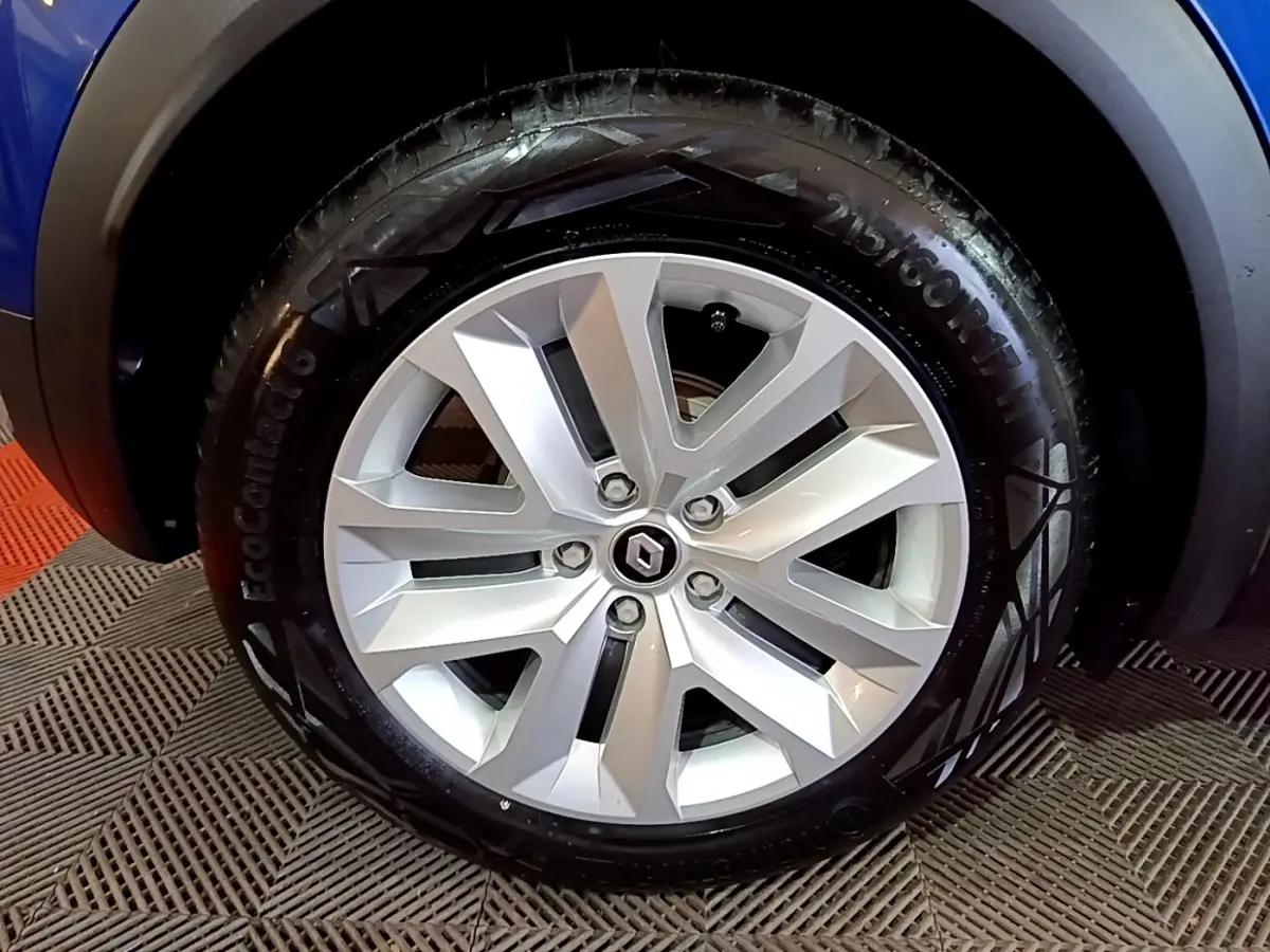 Gros plan sur la roue avant gauche du Renault Captur bleu 2023, mettant en valeur la jante alliage et le pneu EcoContact 6.