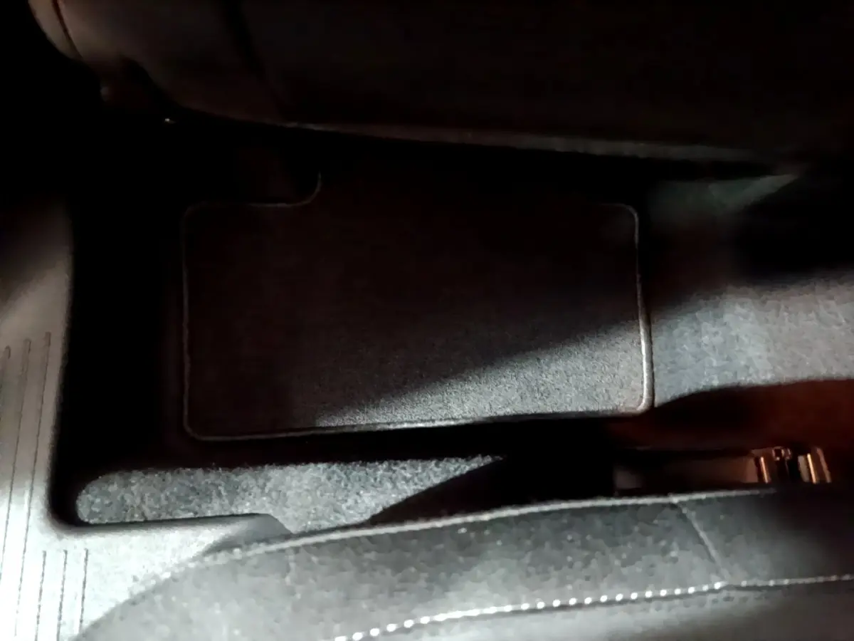 Vue rapprochée du tapis de sol arrière côté droit du Renault Captur bleu hybride 2023, avec moquette noire.