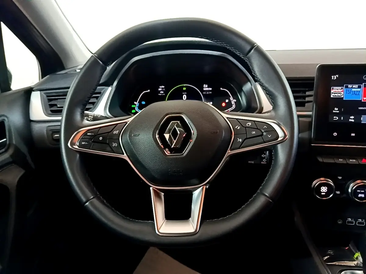 Vue intérieure centrée sur le volant cuir du Renault Captur 2023, avec tableau de bord numérique et écran tactile.