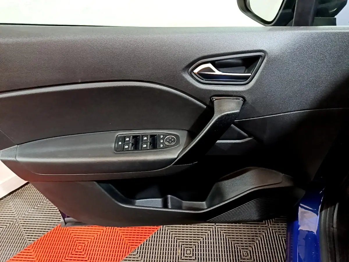 Vue intérieure du panneau de porte avant gauche du Renault Captur bleu, avec commandes électriques des vitres et poignée noire.