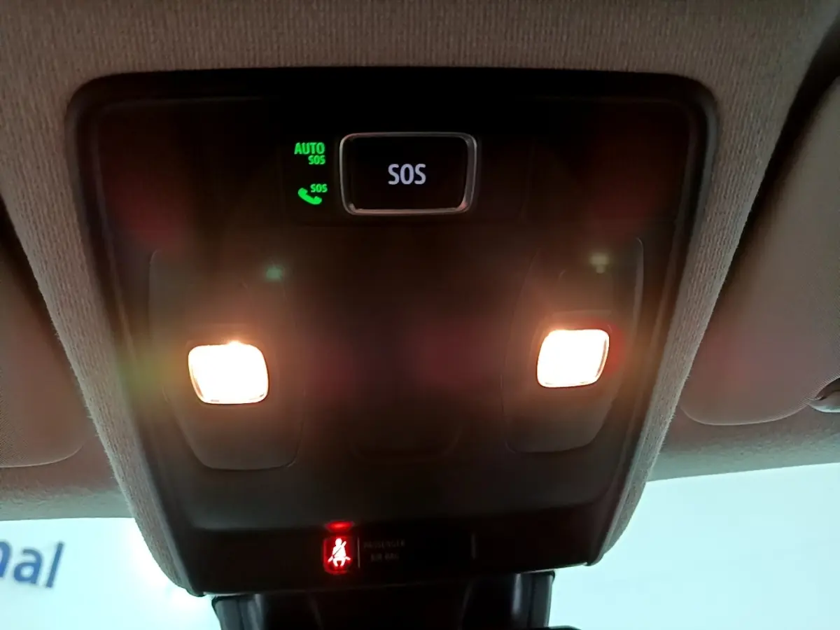 Vue intérieure du plafonnier avec éclairage et bouton SOS allumé dans un Renault Captur bleu hybride 2023.