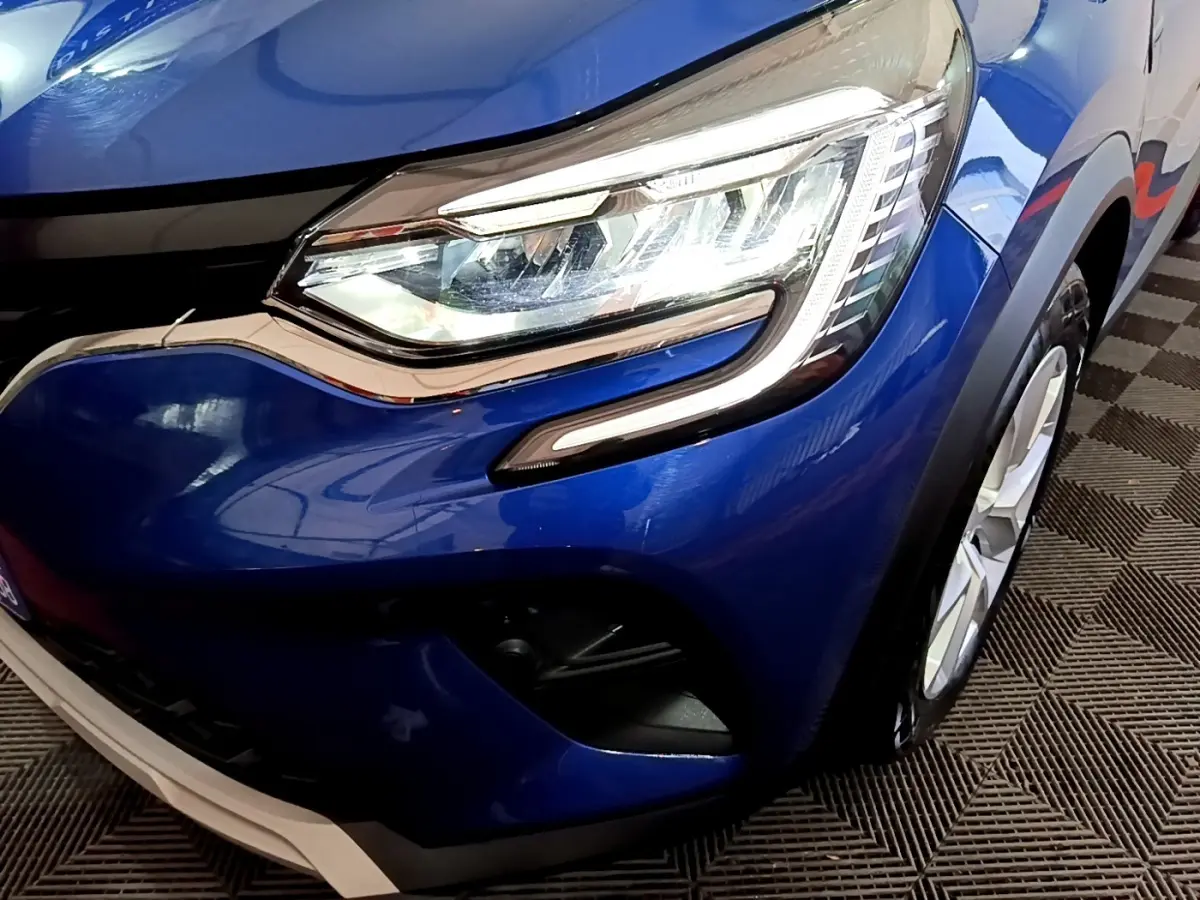 Gros plan sur l'avant droit bleu du Renault Captur 2023 avec phare LED et partie de la roue visible.