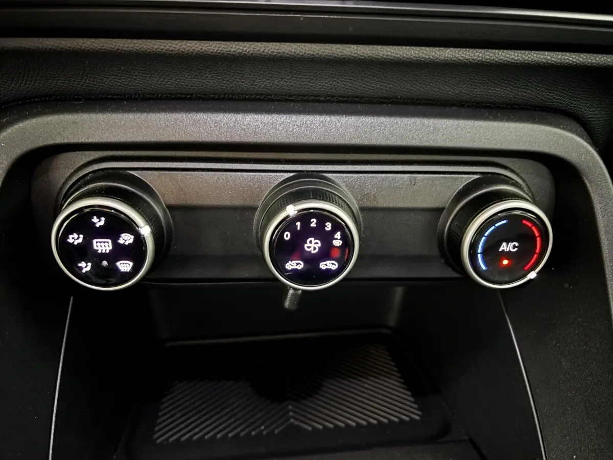 Gros plan sur les commandes de climatisation noire de la Citroën C3 100 BVM PLUS 2025, avec réglages éclairés.