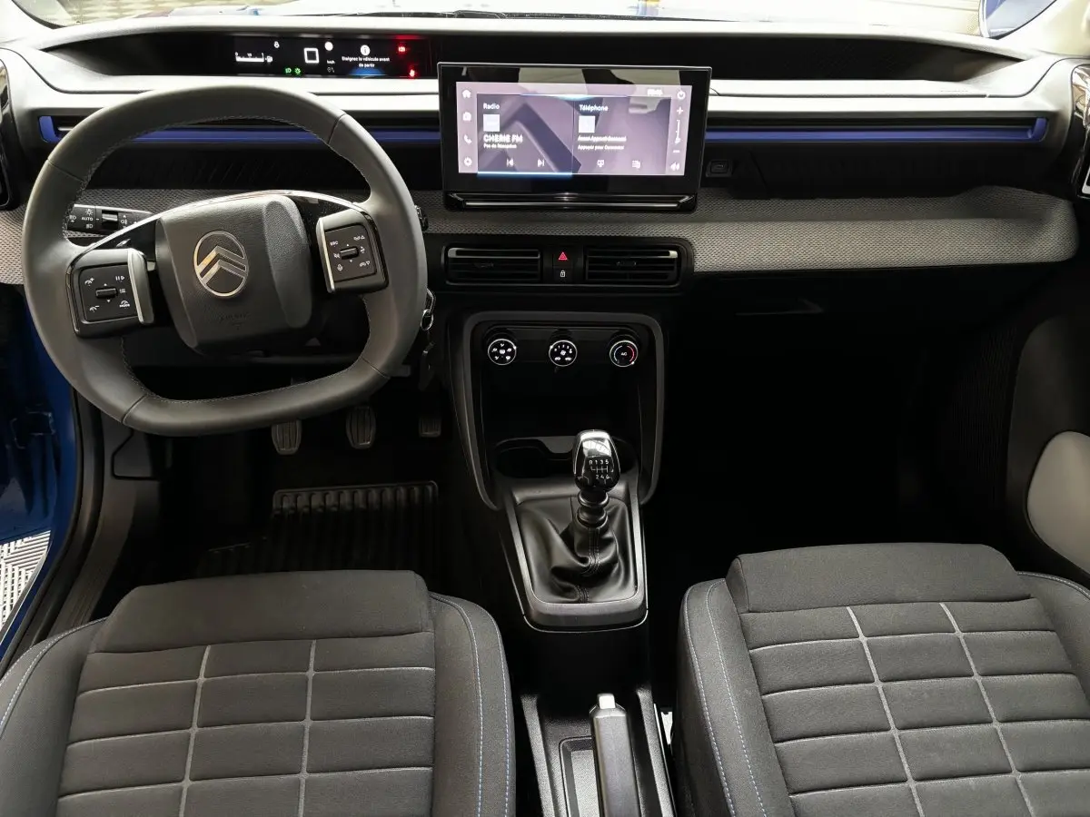 Vue intérieure avant de la Citroën C3 2025 noire, volant cuir multifonctions, écran tactile central 10,25 pouces et boîte manuelle.