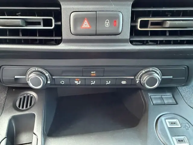 Vue rapprochée du tableau de bord du Citroën Berlingo blanc 2026, avec commandes de climatisation et ventilation.