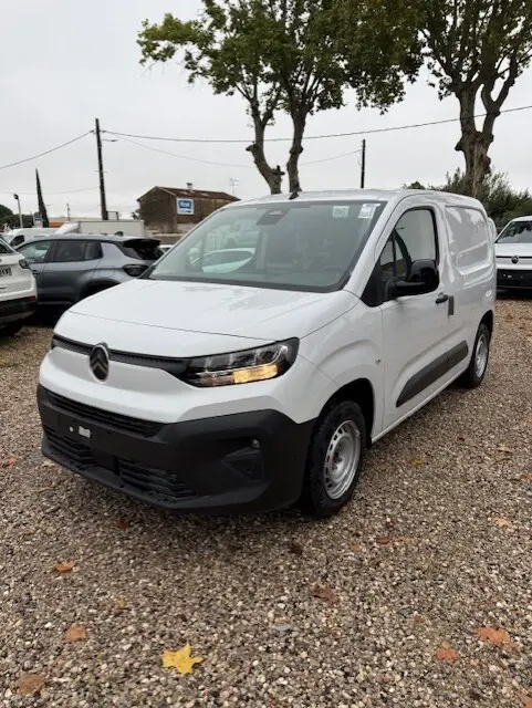 Citroën Berlingo Van Diesel blanc vu en 3/4 avant droit sur un sol gravillonné avec phares allumés.