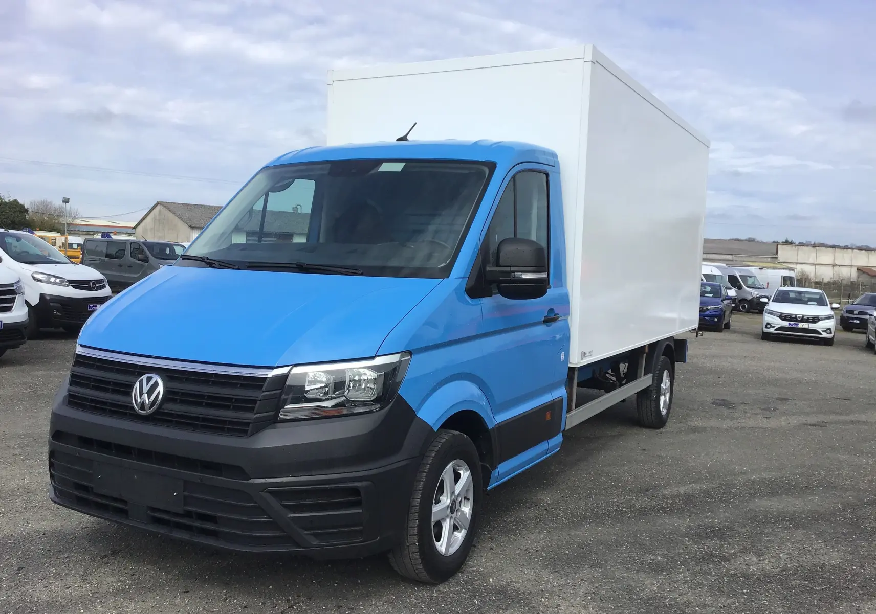 Volkswagen Crafter châssis cabine bleu vue 3/4 avant droit avec caisse blanche et jantes alu 16 pouces.