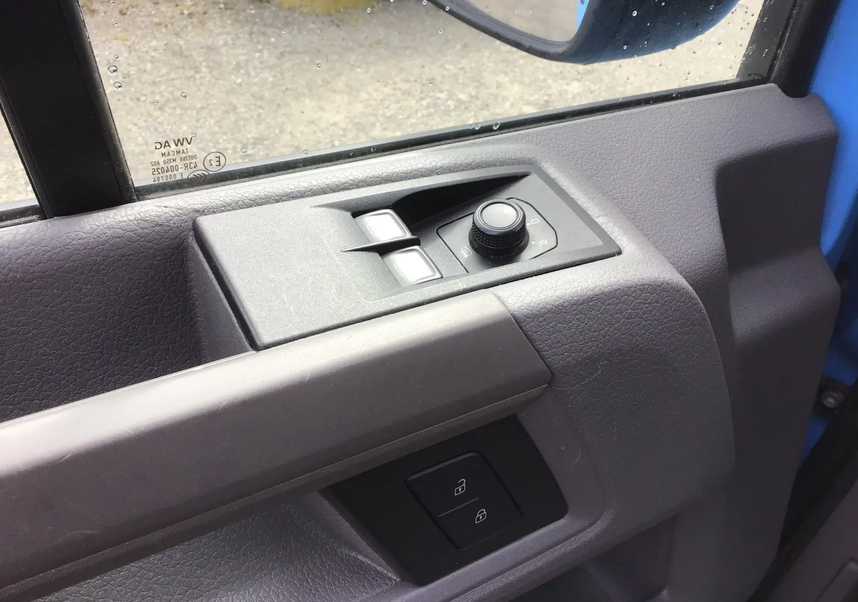 Détail de la commande des vitres et rétroviseurs côté conducteur du Volkswagen Crafter bleu 2017, portière ouverte.