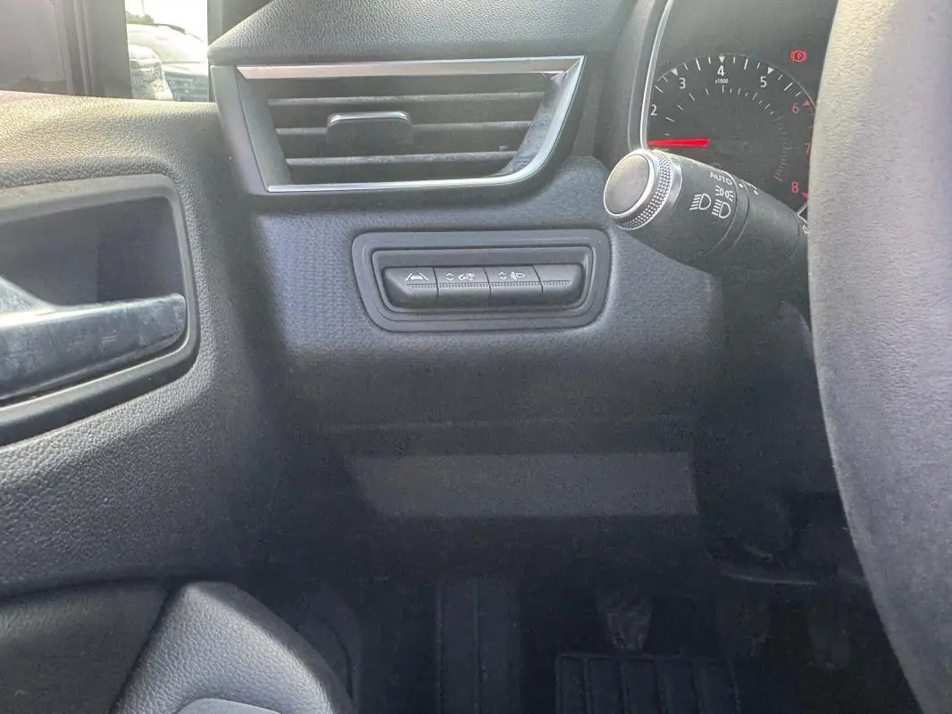 Détail intérieur côté gauche du tableau de bord de la Renault Clio gris foncé, avec commandes et levier d’éclairage visibles.