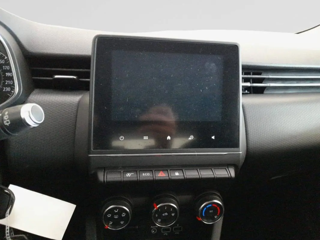 Écran tactile central et commandes de climatisation sur le tableau de bord de la Renault Clio gris foncé, vue intérieure frontale.