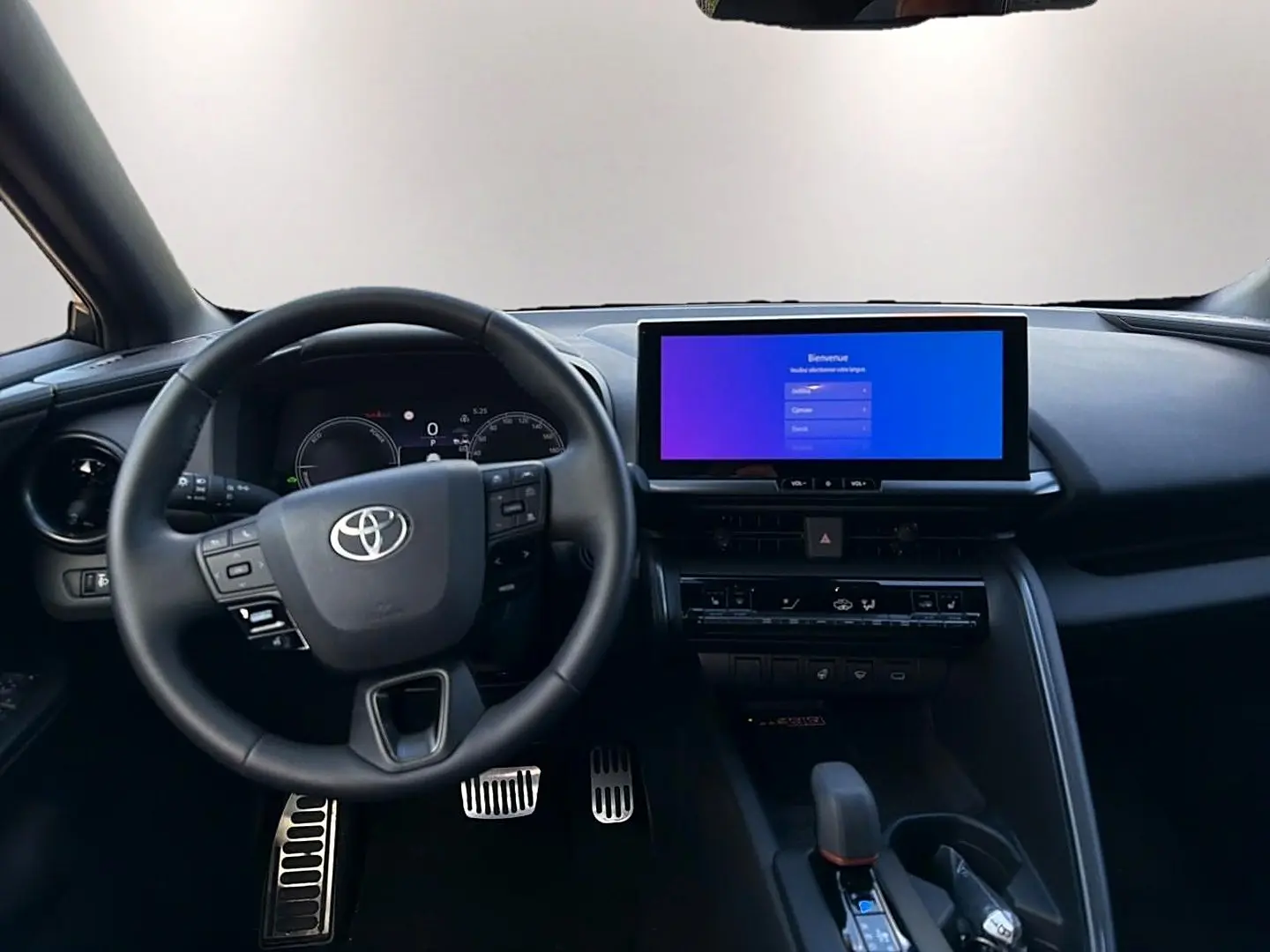 Vue frontale de l'intérieur noir du Toyota C-HR 1.8 hybride 2025 avec écran tactile large et volant multifonction.