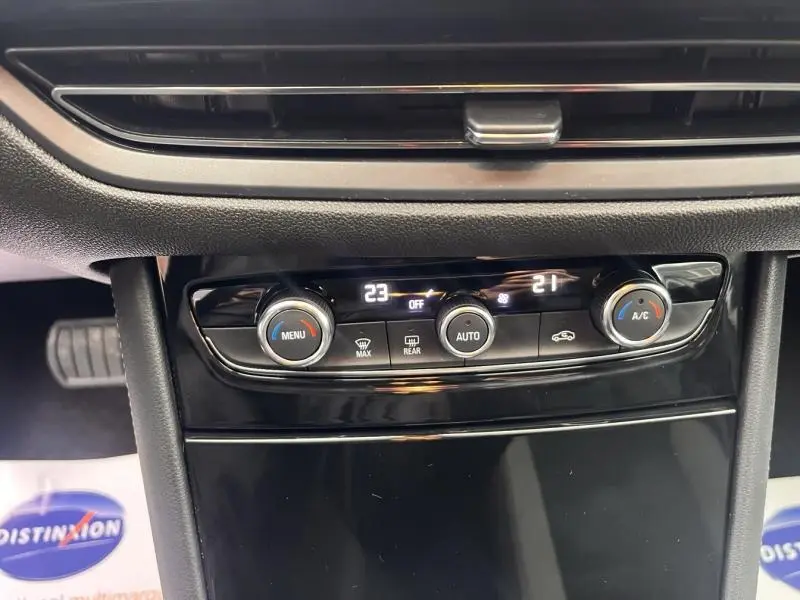 Gros plan sur la console centrale du Opel Grandland 2023, avec commandes de climatisation bi-zone et affichage digital.