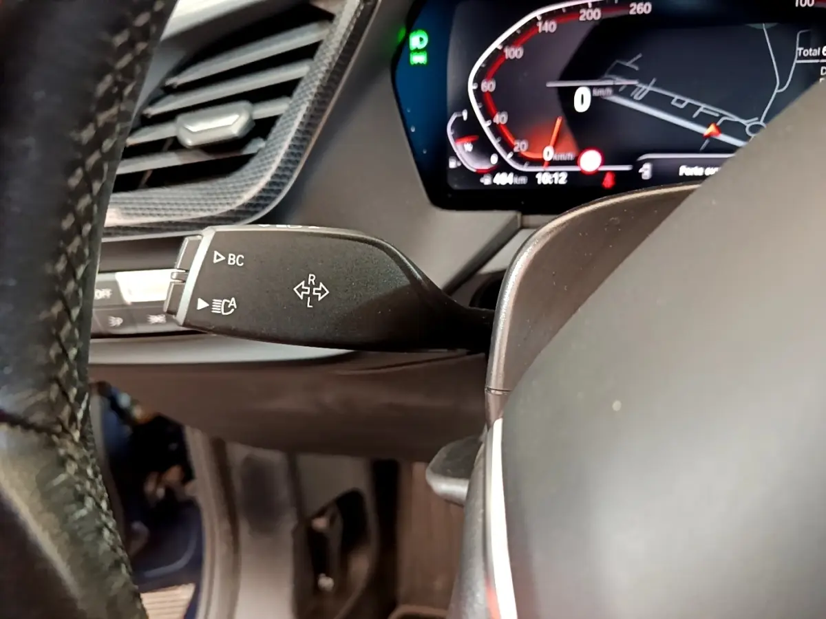 Gros plan sur la commande de clignotants à gauche du volant dans le tableau de bord numérique d'une BMW Série 1 bleue 2023.
