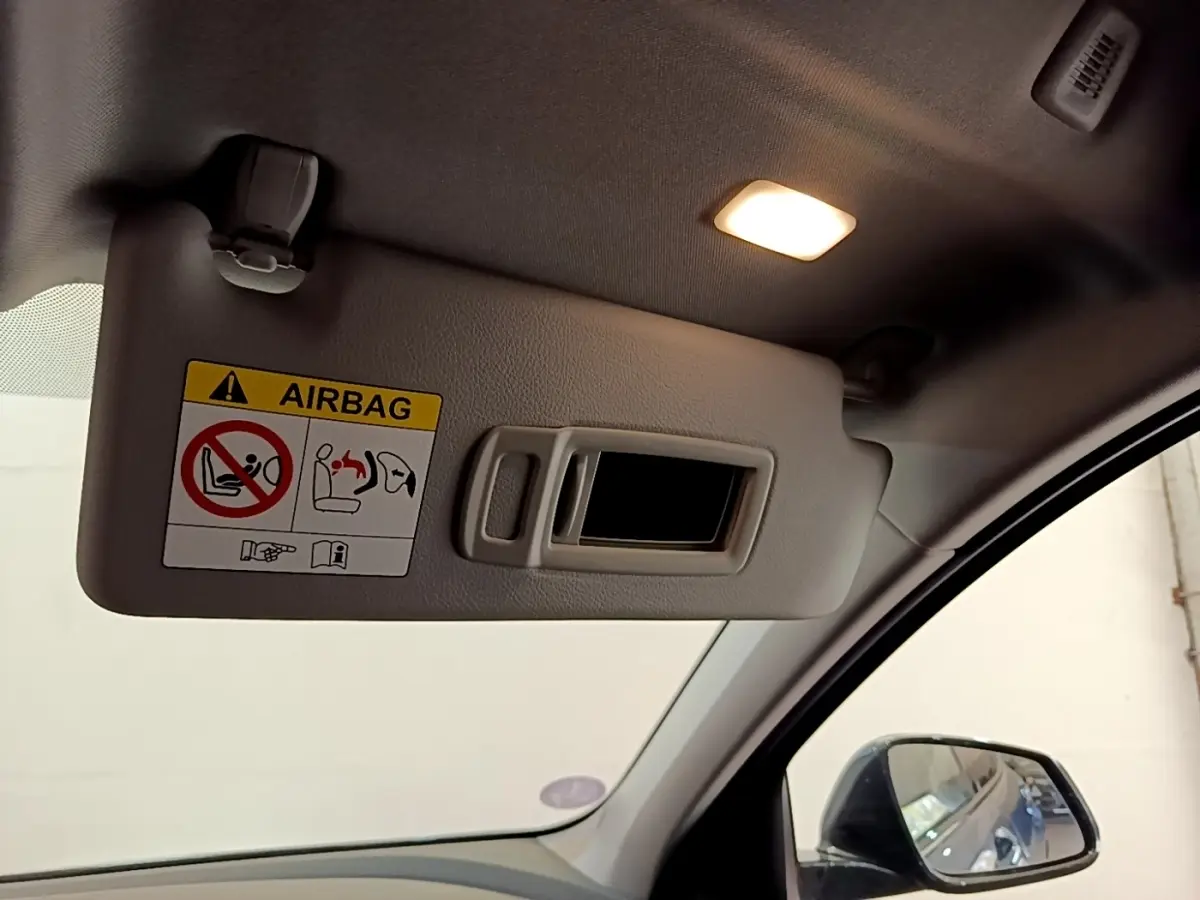 Détail du pare-soleil côté conducteur avec miroir intégré et avertissement airbag dans l’habitacle d’une BMW Série 1.