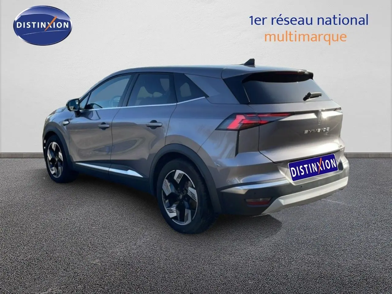 Renault Symbioz gris cassiopée métal, vue 3/4 arrière droit, SUV hybride avec jantes bi-ton et feux LED distinctifs.