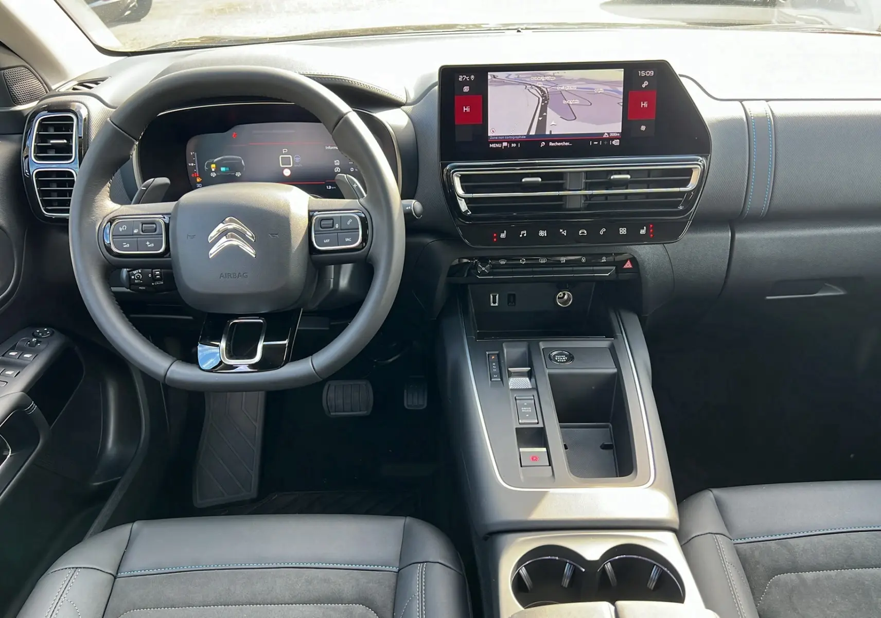 Intérieur du Citroën C5 Aircross Hybrid 145 2025, vue frontale sur le tableau de bord et le volant noir avec coutures bleues.