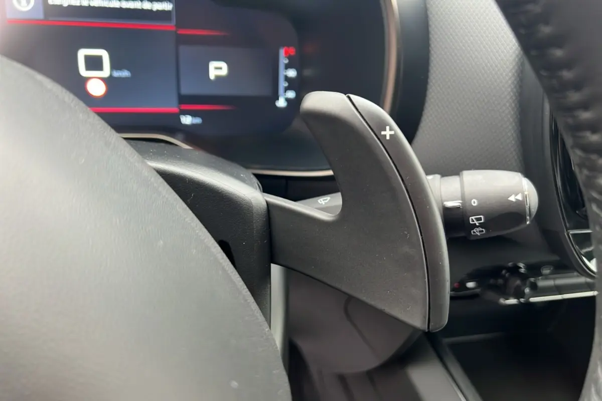 Gros plan sur la palette de changement de vitesse côté droit du volant du Citroën C5 Aircross Hybrid 2025, intérieur noir.