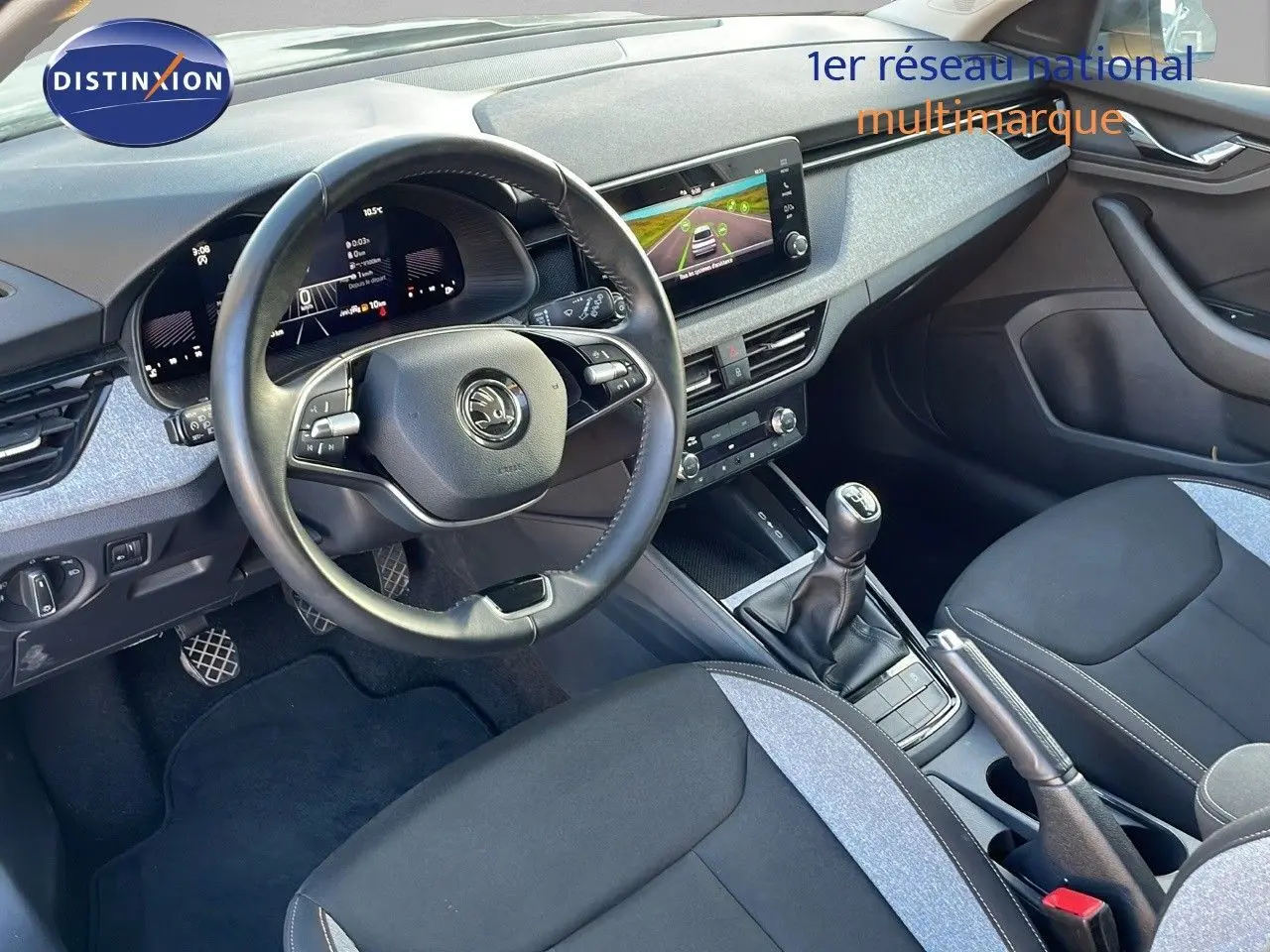 Intérieur avant du Skoda Kamiq 2024 essence gris graphite, volant multifonction, tableau de bord digital et boîte manuelle.