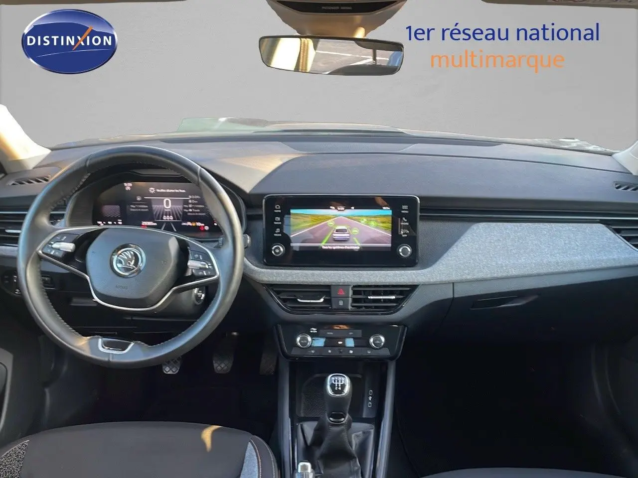 Vue intérieure avant du Skoda Kamiq 2024 gris graphite, avec tableau de bord numérique et écran tactile central.