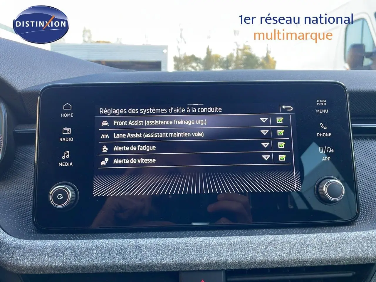 Écran tactile central du Skoda Kamiq 2024 affichant les réglages d'aides à la conduite avec interface moderne.