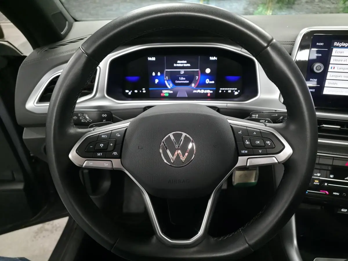 Vue frontale du volant en cuir noir multifonction du Volkswagen T-Roc 2024 avec tableau de bord numérique éclairé.