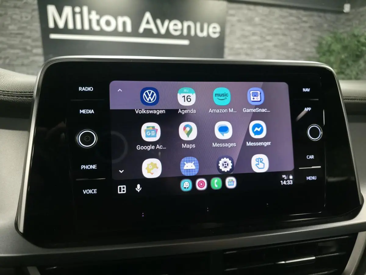 Écran tactile central du Volkswagen T-Roc 2024 affichant les applications connectées avec cadre noir brillant.