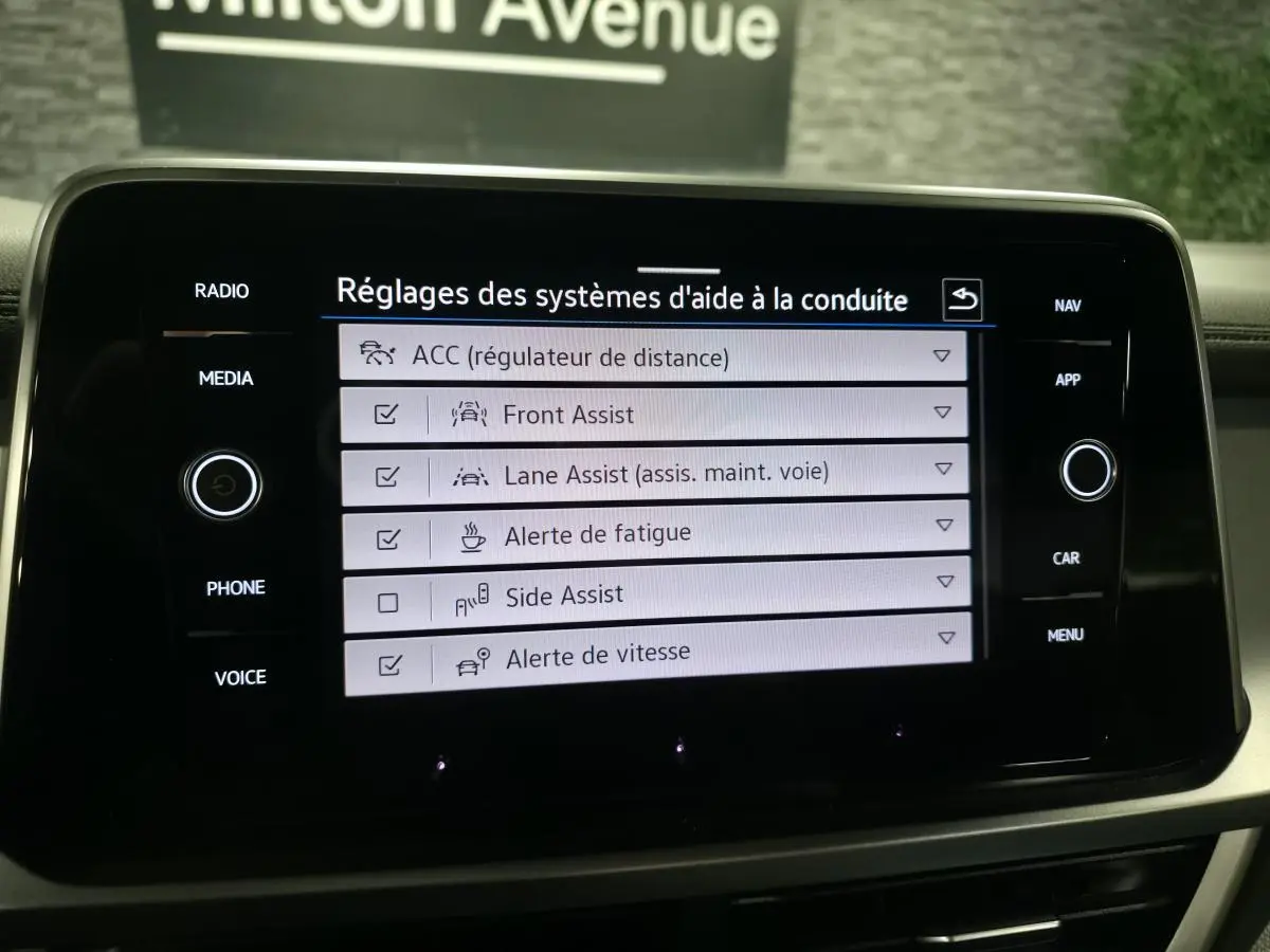 Écran tactile intérieur du Volkswagen T-Roc 2024 affichant les réglages des aides à la conduite.