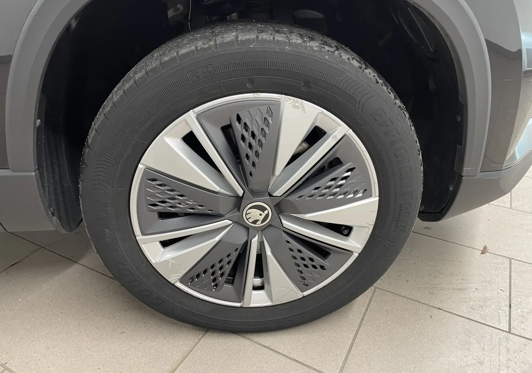 Gros plan sur la roue avant gauche du Skoda Karoq noir Magic nacré, avec jante alliage au design moderne.