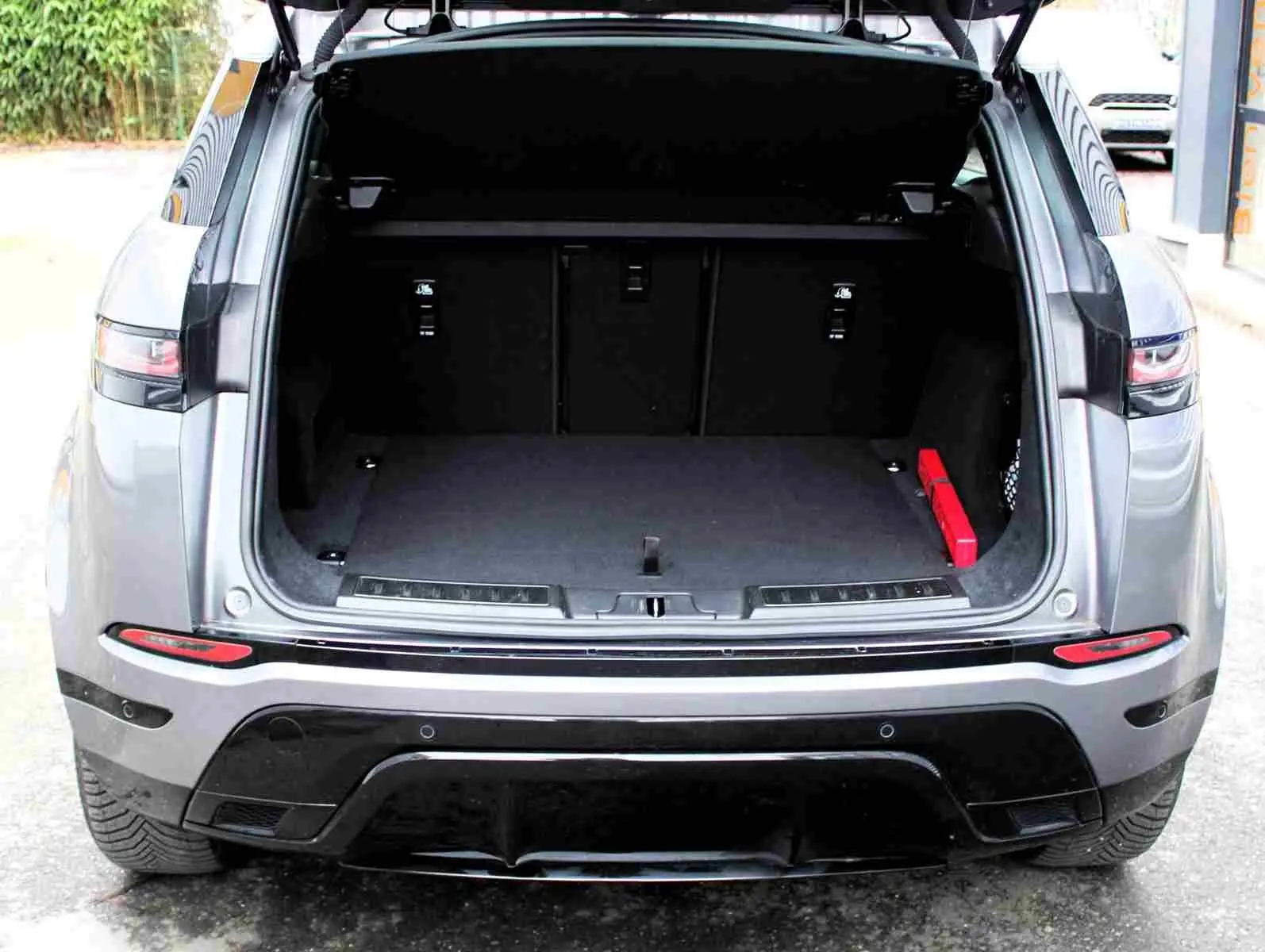 Vue arrière d'un Range Rover Evoque gris métal 2023 avec coffre ouvert et intérieur de coffre vide.
