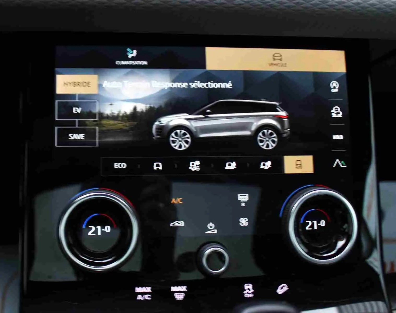Écran tactile intérieur montrant le profil gris métal du Range Rover Evoque hybride rechargeable, avec commandes climatisation à 21°C.