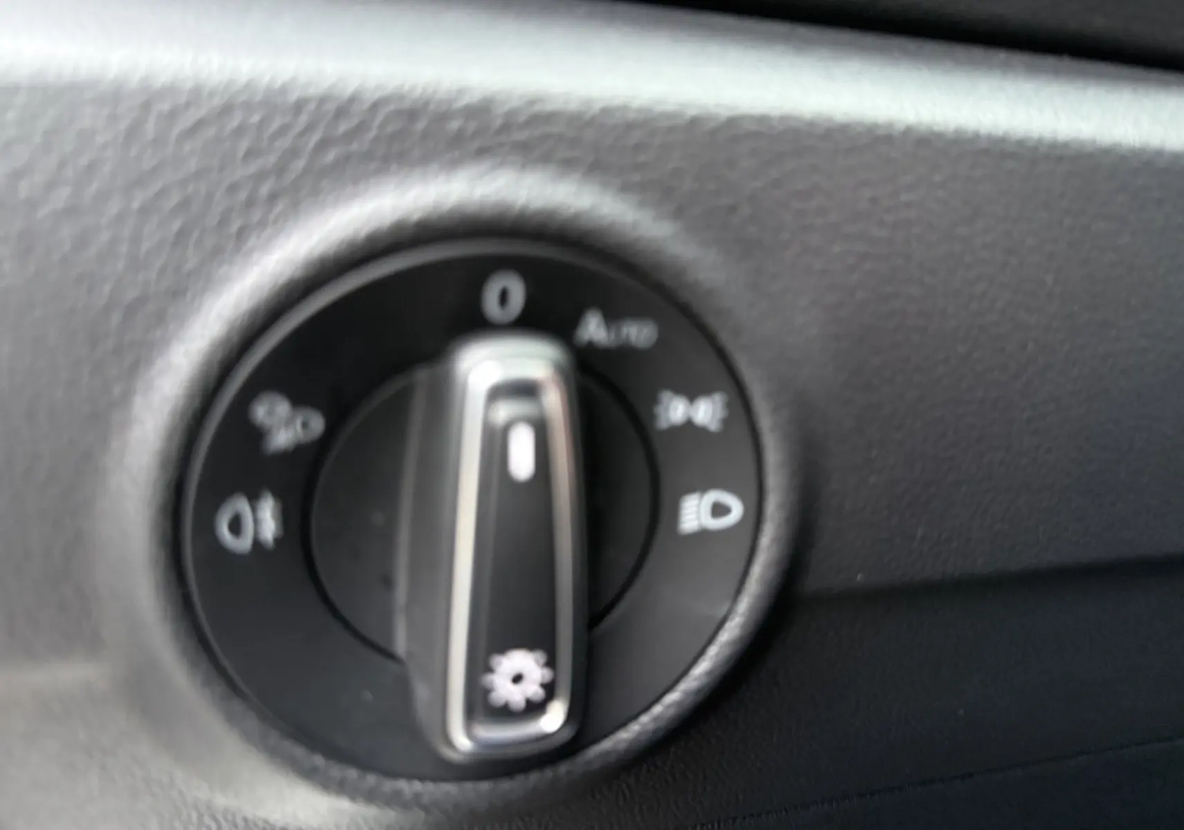 Gros plan sur le sélecteur de commandes d’éclairage intérieur du Volkswagen T-Roc 2025, tableau de bord noir.