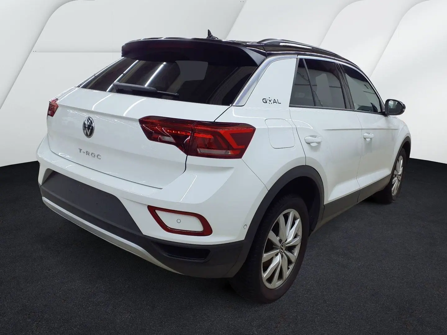 Volkswagen T-Roc blanc pure avec toit noir, vue 3/4 arrière droit, feux arrière LED et jantes alliage.