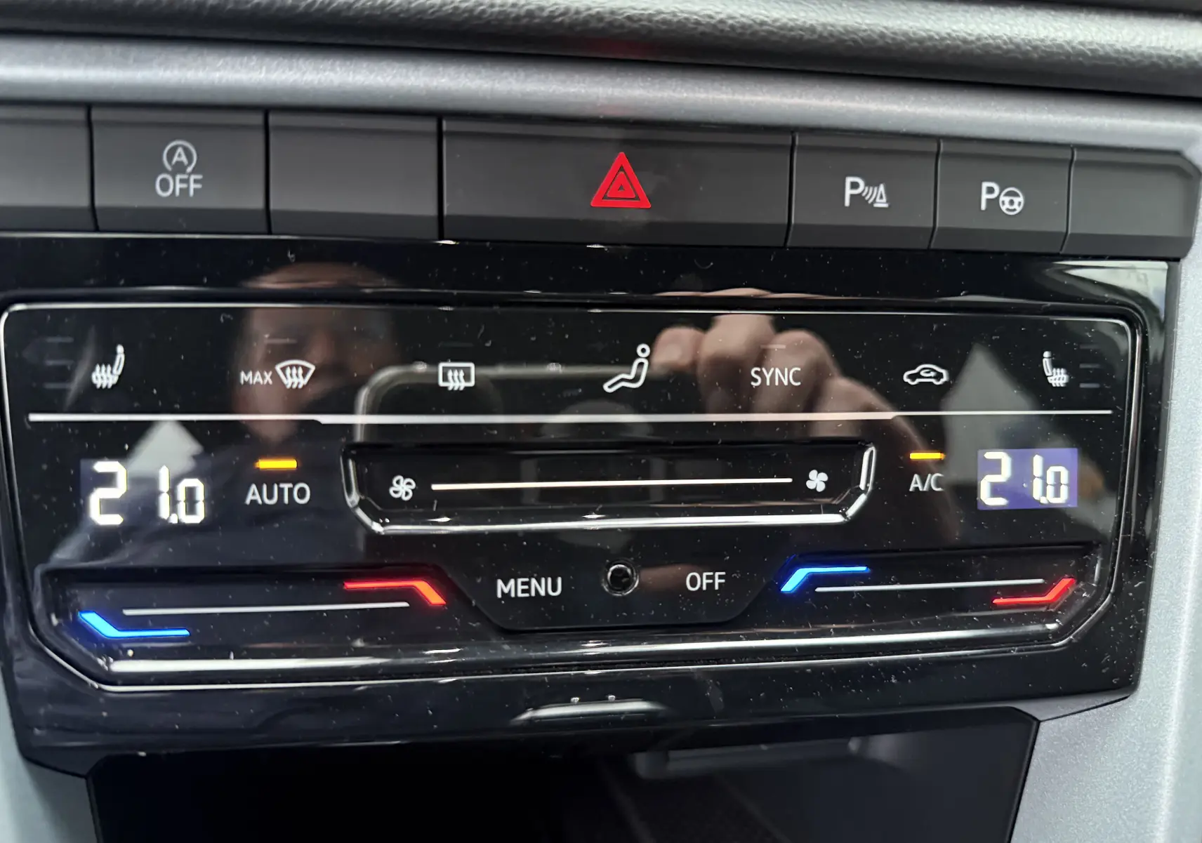 Panneau de commande de la climatisation digitale du Volkswagen T-Roc 2025 avec réglage à 21°C et boutons tactiles.